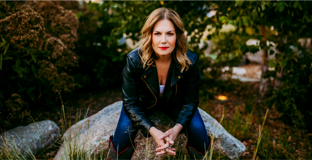 Jane Kleeb sitting with hands together and looking at the camera